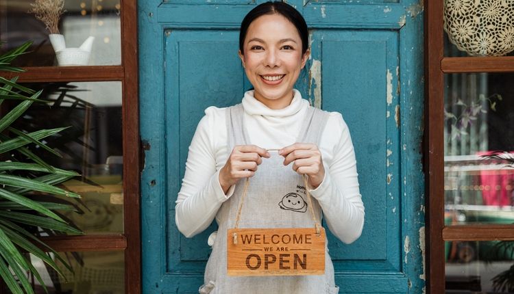 Cafe owner holding a welcome sign